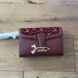 Coach embroidered Elegant Burgundy Clutch with Gold Accent.